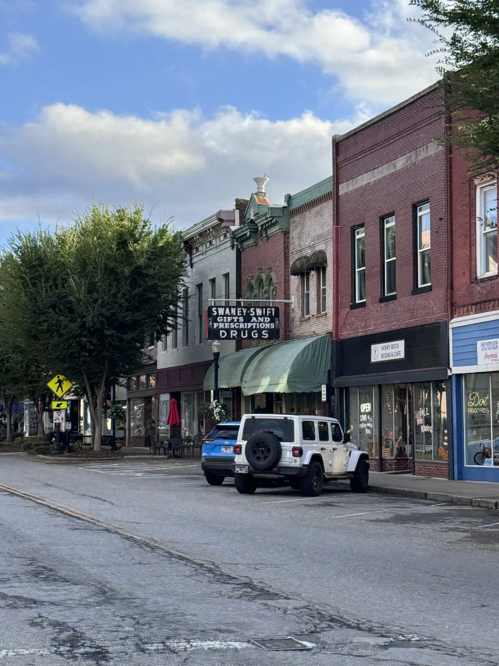 Historic brick storefronts and a vintage pharmacy sign along a downtown Gallatin, Tennessee, street.