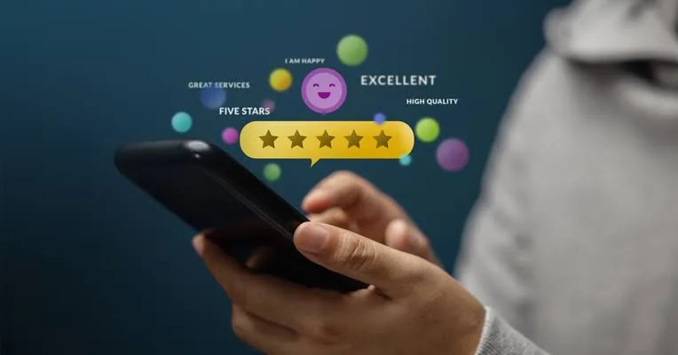 A customer holding a phone with a five-star review rating on screen