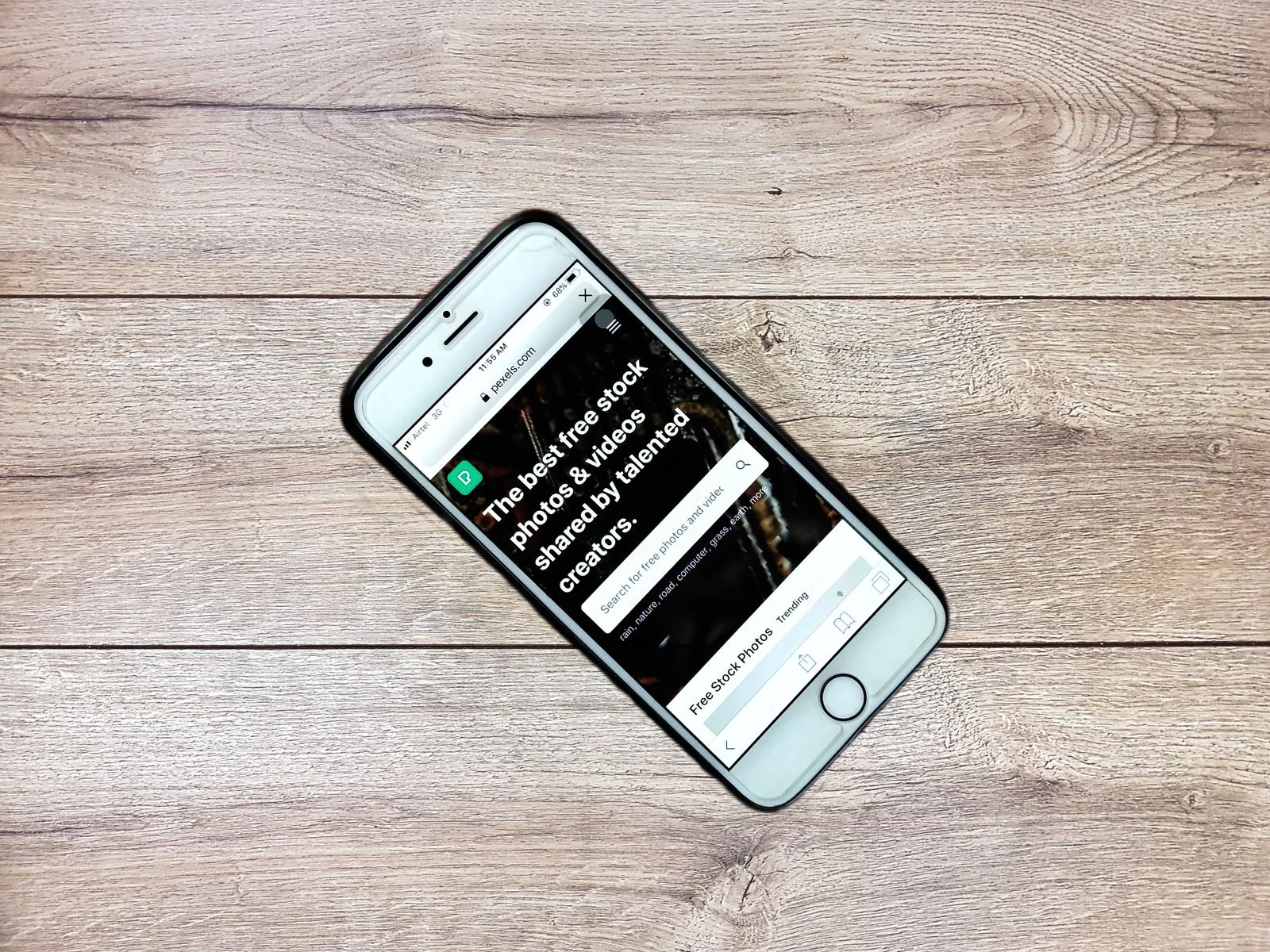 A smartphone with a business website open, placed on a wooden table, viewed from above